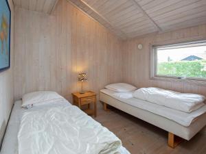 dwa łóżka w pokoju z oknem w obiekcie Holiday home Væggerløse CLXXVIII w mieście Bøtø By