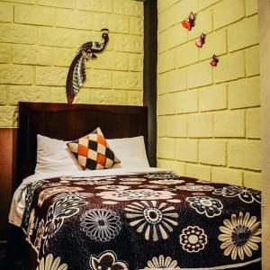 a bedroom with a bed with a floral comforter at El Sueño de Quetzalcoatl in San Juan Teotihuacán