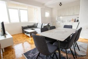 a living room with a table and chairs and a couch at S-Apartment Ohrid in Ohrid