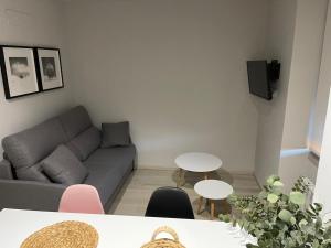 un soggiorno con divano e 2 tavoli di Apartamento Puertas del Orbigo 1 a Carrizo de la Ribera