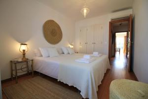 a bedroom with a large white bed and a table at Sea House in Viana do Castelo