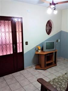 a room with a door and a tv on a table at Jardim de Londres - Sobrado em Campinas in Campinas