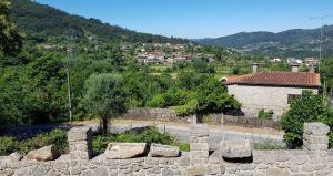 eine Steinmauer mit einem Dorf im Hintergrund in der Unterkunft Quinta do Avô - Casa de Campo in Terras de Bouro + 36 Fotos