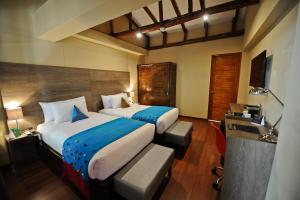 a hotel room with two beds and a television at Union Hotel Cusco in Cusco +59 photos