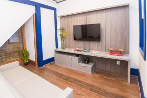 a living room with a television on a wall at Pousada Ouro Real in Mariana