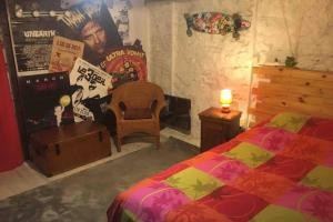 a bedroom with a bed and a chair and a wall at maison Appart du mont july in Ceyzériat