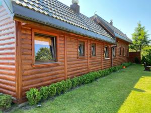a wooden cabin with a window on the side of it at ZEFIR Dąbki in Dąbki