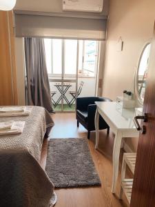 a room with a bed and a desk and a window at 7 Castelos in Oeiras