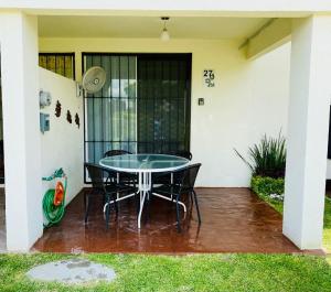 un patio con mesa y sillas frente a una casa en "Casa Bonita" fte alberca, AirAc, en Alpuyeca