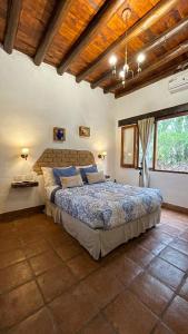 a bedroom with a large bed and a wooden ceiling at Pasillos del Viñedo in Cafayate