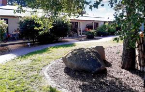 a rock sitting in the grass next to a tree at 2 Bedroom Lovely Home In Fuhlendorf in Fuhlendorf