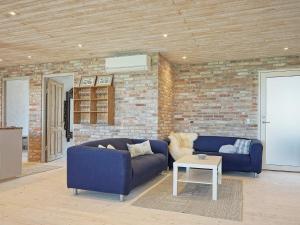 斯瓦納克的住宿－6 person holiday home in Svaneke，客厅设有2张蓝色的沙发和砖墙