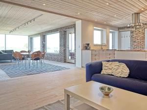 uma sala de estar com um sofá azul e uma mesa em 6 person holiday home in Svaneke em Svaneke