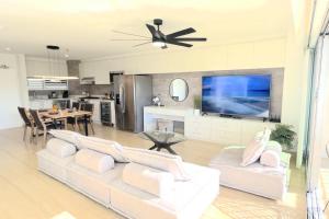 a living room with a white couch and a television at Waikiki Shore 1116 Beachfront in Honolulu