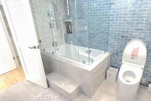 a bathroom with a bath tub and a toilet at Waikiki Shore 1116 Beachfront in Honolulu +12 photos