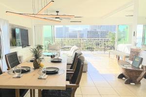 a dining room with a table and a view of the city at Waikiki Shore 1116 Beachfront in Honolulu