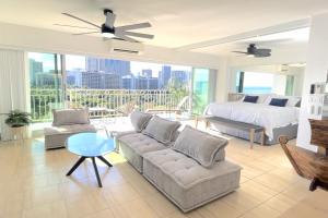 a bedroom and living room with a bed and a couch at Waikiki Shore 1116 Beachfront in Honolulu