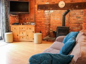 a living room with a couch and a brick wall at Garden Cottage in Kerry