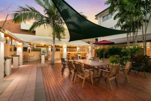 a patio with a table and chairs on a deck at Cairns Queens Court in Cairns