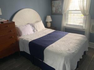a bedroom with a bed and a dresser and a window at Ocean Manor 1100 Inn in Ocean City