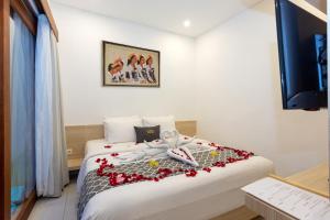 una camera d'albergo con un letto con fiori rossi di Radea Villa a Kerobokan