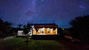 ein Haus unter einem Sternenhimmel mit einem Gebäude in der Unterkunft Palm Villa Ishigakijima fusu in Ishigaki-jima