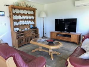 a living room with a couch and a coffee table at Sunset Point Kerikeri in Kerikeri