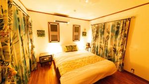 ein Schlafzimmer mit einem Bett in einem Zimmer in der Unterkunft Palm Villa Ishigakijima fusu in Ishigaki-jima
