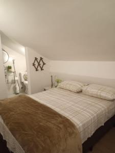 Apartamento Temporada Palácio Quitandinha em Petrópolis RJ في بتروبوليس: غرفة نوم بيضاء مع سرير مع وسادتين