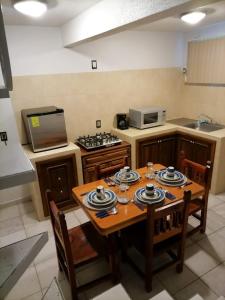 een keuken met een houten tafel met stoelen en een fornuis bij Loft in Ciudad Hidalgo