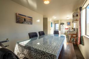 a dining room with a glass table and chairs at 11b Leamington Street in Hanmer Springs