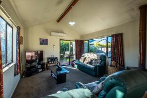 a living room with a couch and a tv at 11b Leamington Street in Hanmer Springs