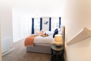 a bedroom with a large bed with an orange blanket at King Street Residence - 2 Bed in Great Yarmouth
