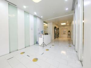 馬尼拉的住宿－OYO 769 Poblacion Suites Polaris，办公室的走廊,铺有白色瓷砖地板