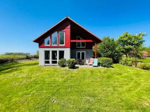 a small red and white house on a green field at Haus am Meer in Hohen Schönberg