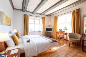Schlafzimmer mit einem großen weißen Bett und einem Schreibtisch in der Unterkunft Hotel de Charme Römerhof in Arbon