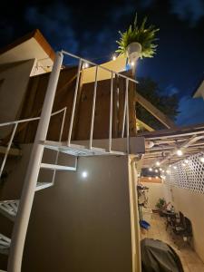 Una escalera en el lateral de una casa por la noche en Relaxing Tropical Studio, en San Juan