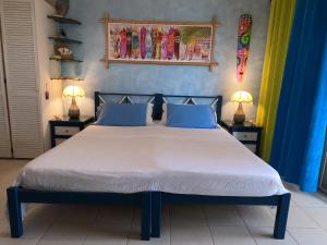 a bedroom with a large bed with blue walls at Green Garden Apartment in Christ Church +48 photos