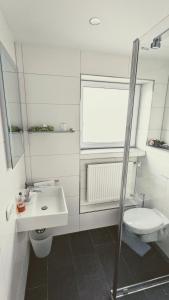 a white bathroom with a sink and a toilet at Hotel Rotes Ross in Erlangen