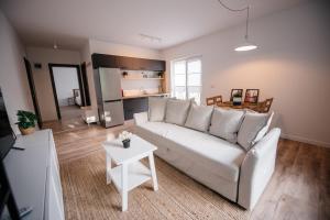 a living room with a white couch and a table at Nuez Residence in Dumbrăviţa