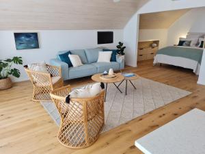 a living room with a couch and a bed at The Boatshed, Luxury Waterfront Accommodation in Raglan