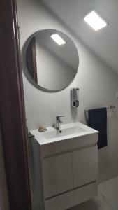 uma casa de banho com um lavatório branco e um espelho. em Casa na Costa em Costa Nova