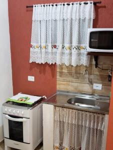 a kitchen with a stove and a sink and a window at Cabana da Montanha - Sítio Pasangas in Santo Antônio do Pinhal