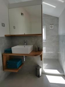 La salle de bains est pourvue d'un lavabo et d'un miroir. dans l'établissement Apartments Casa Tijola, à Sečovlje