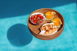 a table with a plate of food and fruit at Evala luxury rooms with pool and garden in Split