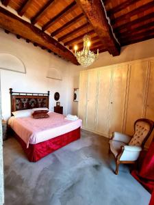 Montemagno的住宿－Casa L Oliveta，一间卧室配有一张大床和一个吊灯。