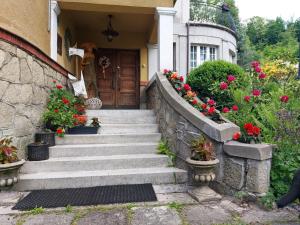 uma casa com escadas que levam a uma porta com flores em Willa Marysin em Maków Podhalański