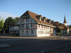 un gran edificio blanco con techo marrón en una calle en Hotel & Restaurant Sternen Köniz bei Bern, en Berna