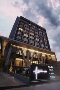 um edifício alto com um sinal em frente em Awann Sewu Boutique Hotel and Suite Semarang em Semarang