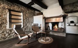 a living room with two chairs and a fireplace at La casa di Montegiardino in San Marino